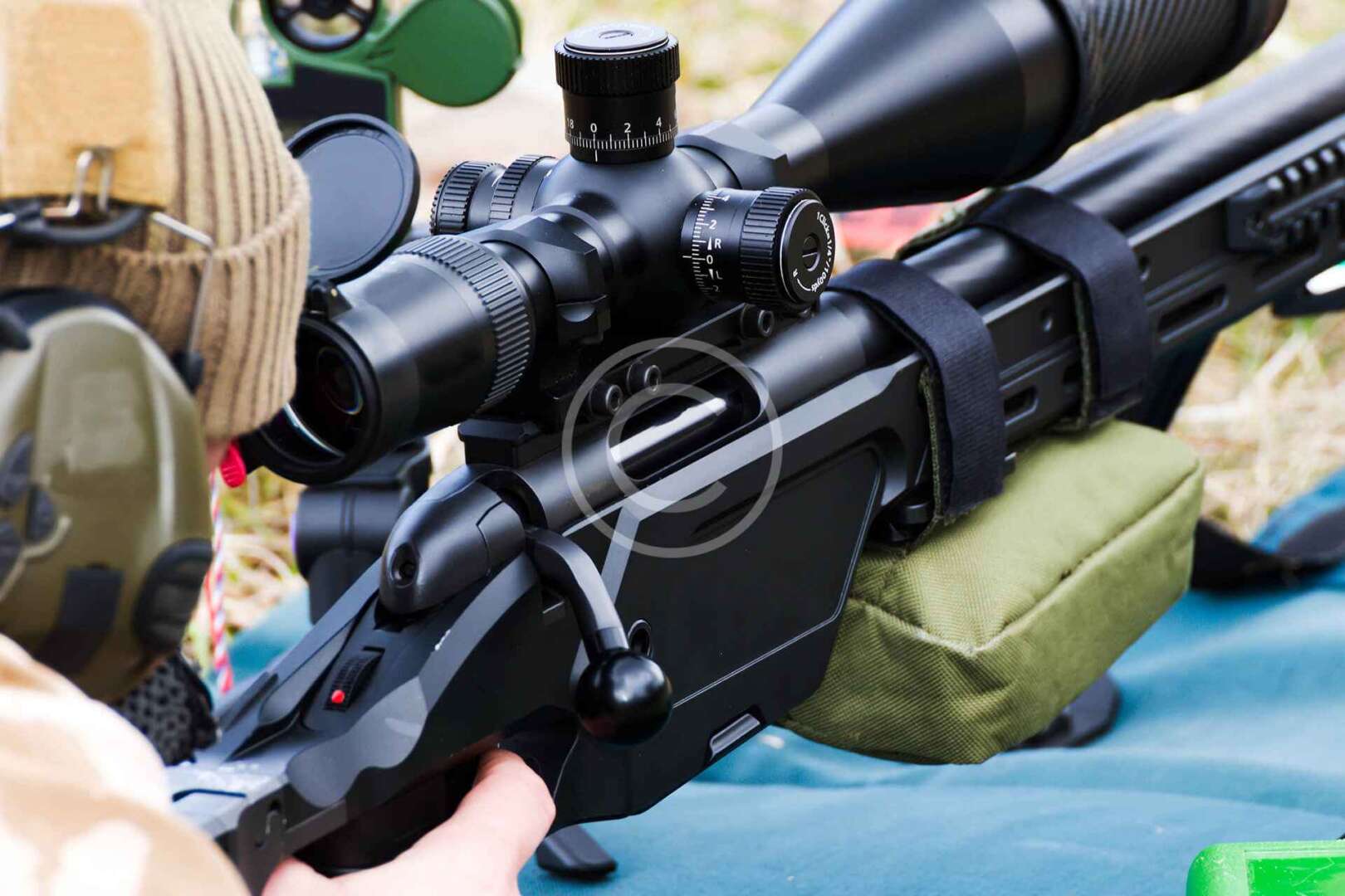 A person is holding a rifle with a scope on it.