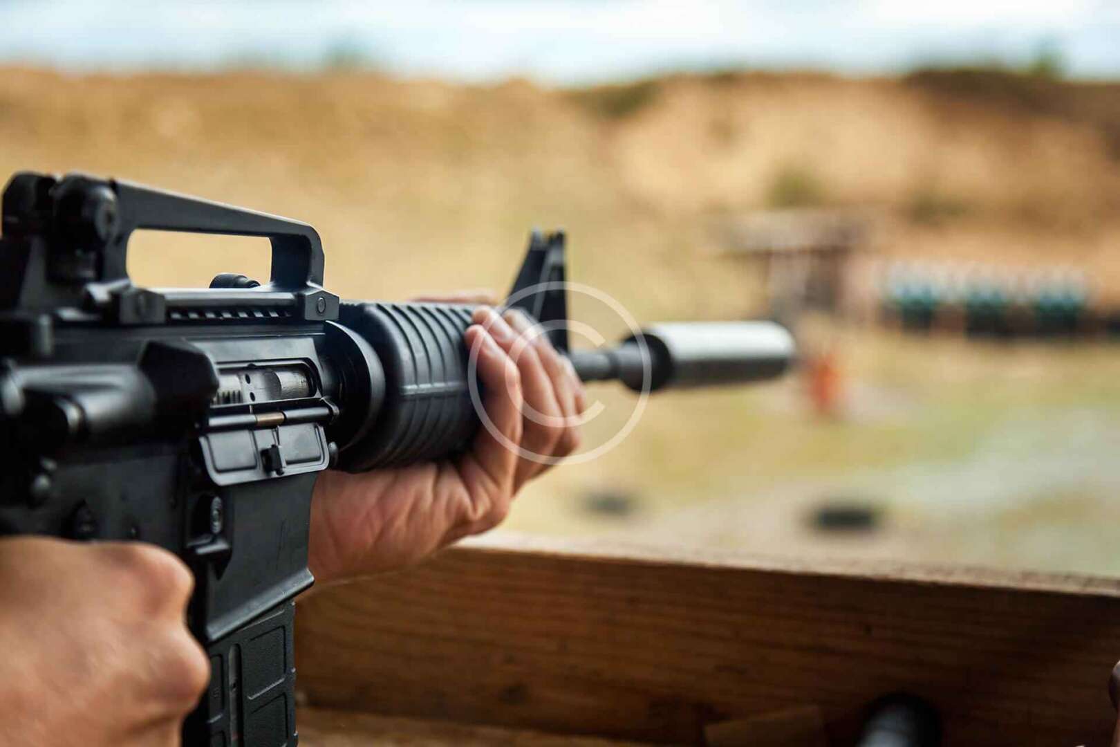 A person is holding an ar - 15 rifle.