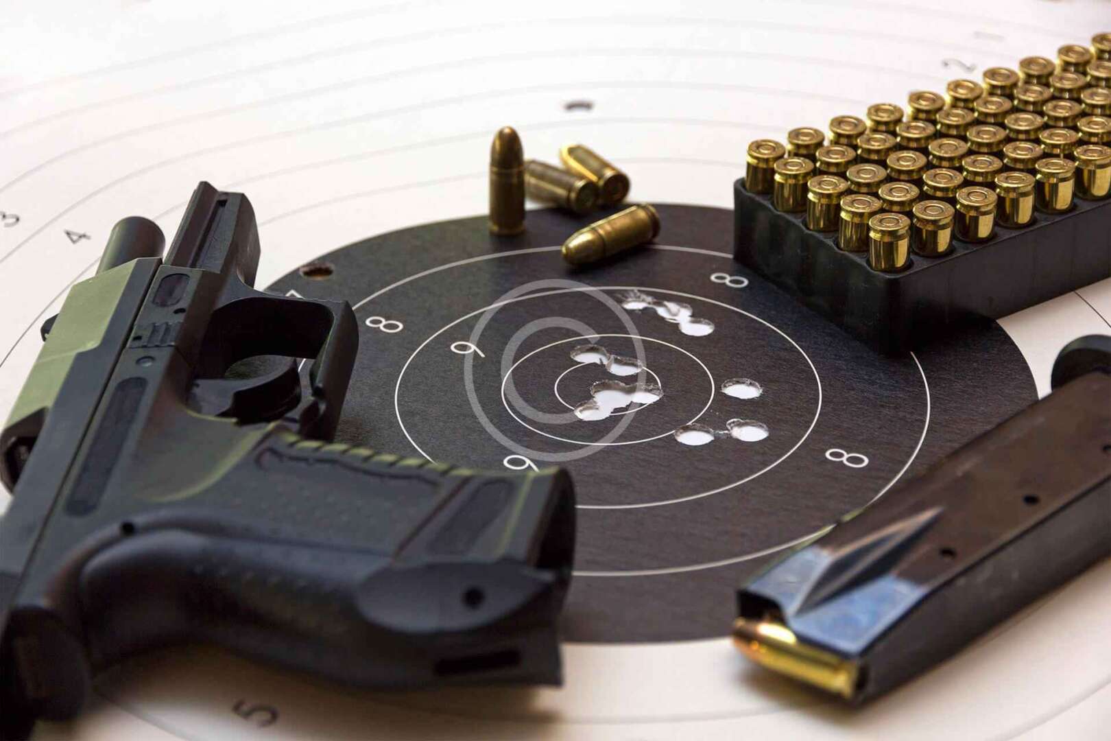 A gun and bullets on a target.