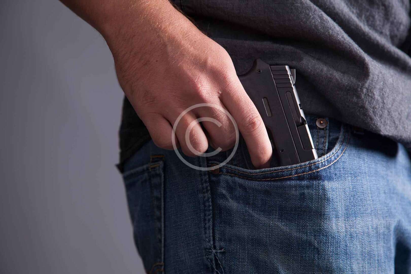 A man is holding a gun in his pocket.
