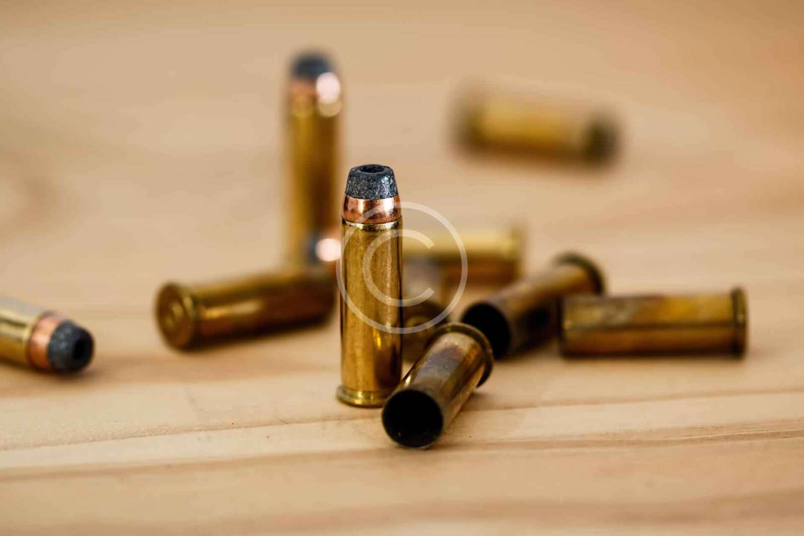 A group of bullets on a wooden table.
