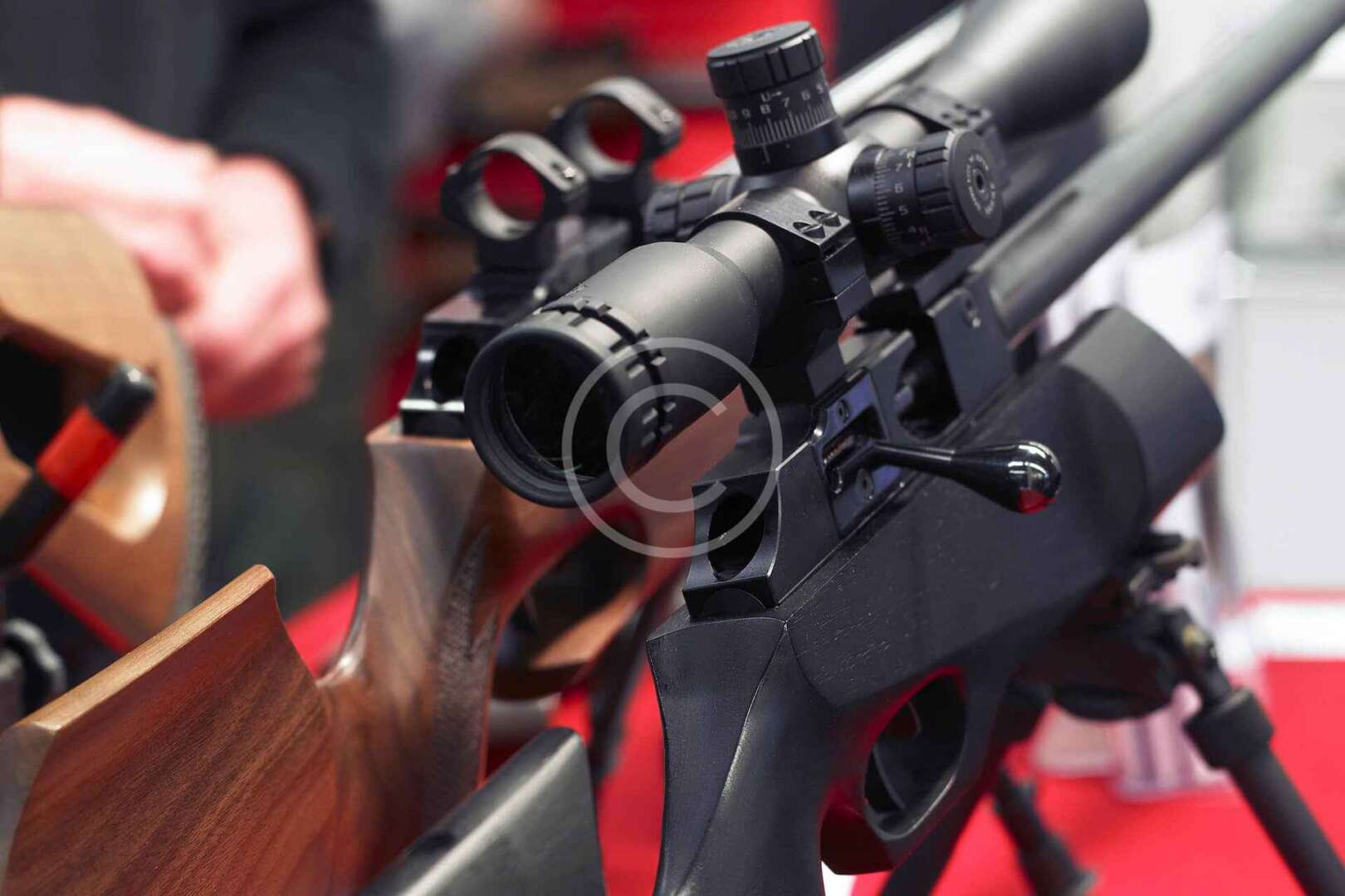 A rifle with a scope is on display at a gun show.