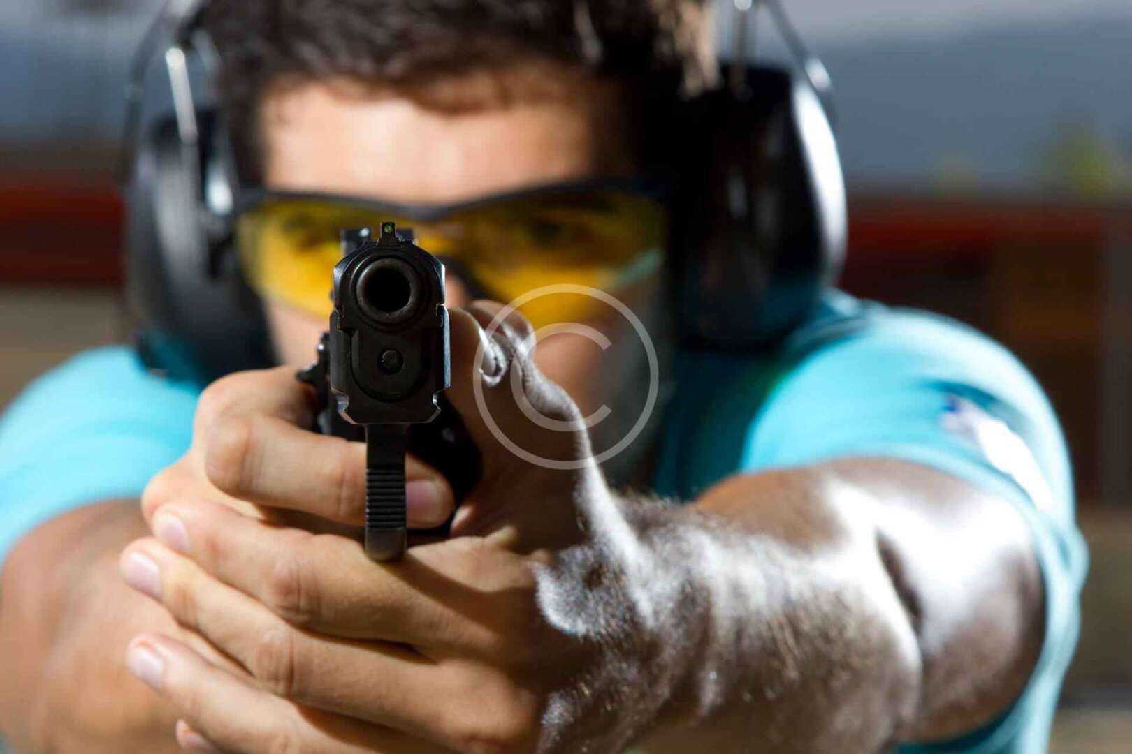 A man is holding a gun and aiming at it.