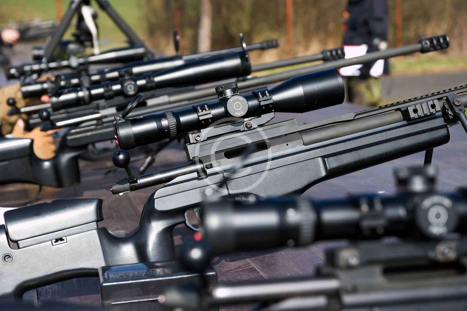 A group of rifles are lined up on a table.